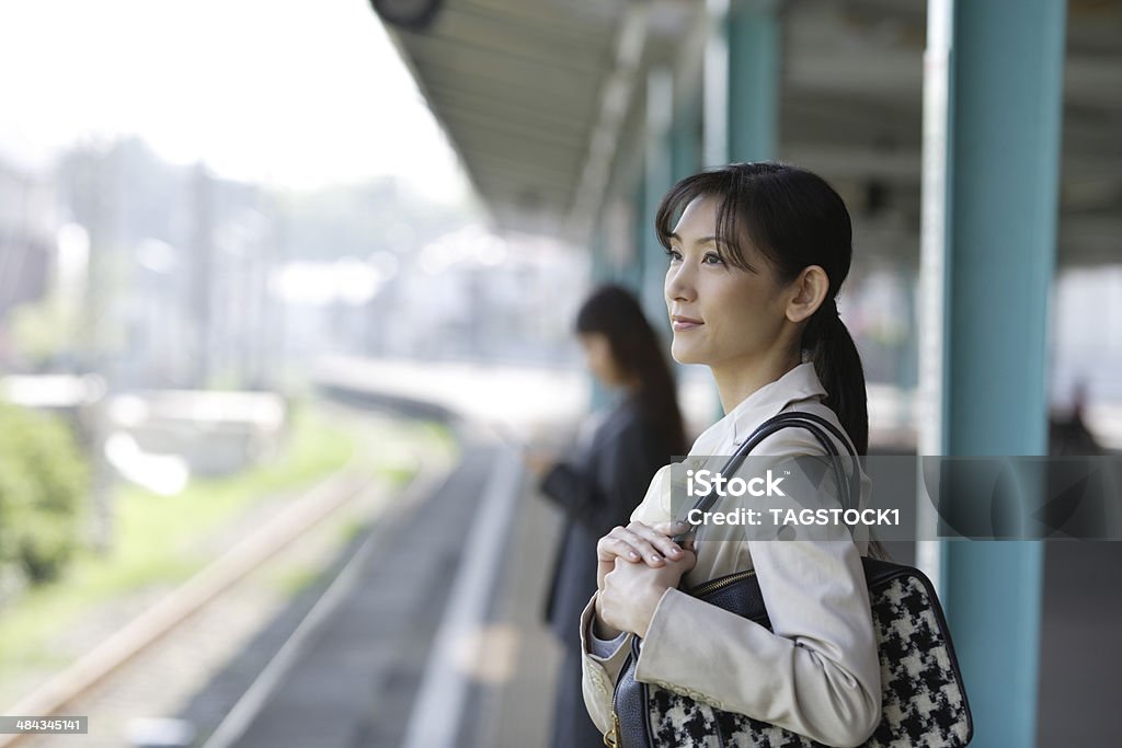 Woman waiting for train on the platform Railroad Station Platform Stock Photo