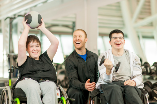 Disabled individuals with trainer working out.