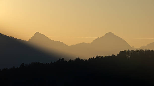 istock Forest and mountain silhouettes at sunrise 484348357
