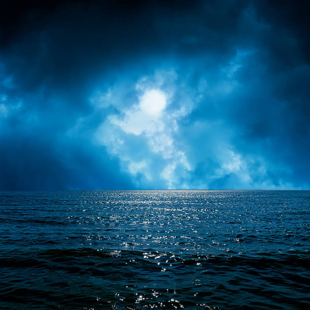 istock moon light in dramatic sky over dark sea 484354392