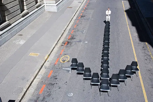 Photo of Businessman standing at office chair in arrow-shape