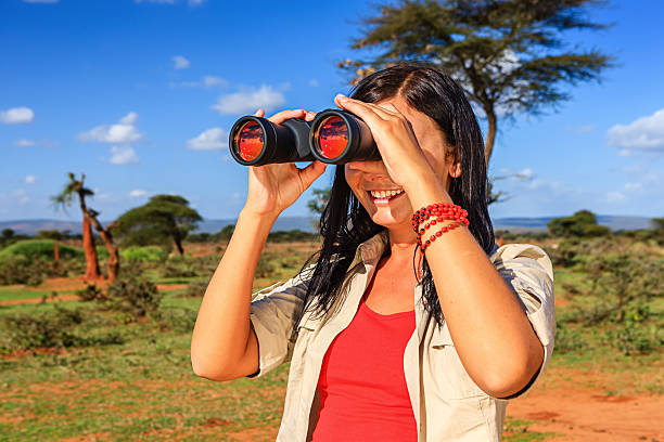 istock Young woman is looking through a binoculars during safari 484357440