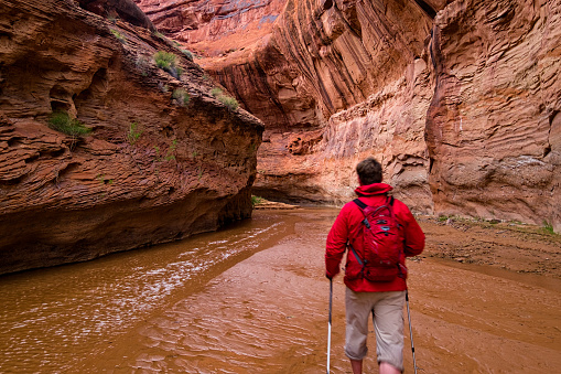 Man Hiking in Slot Canyon Utah - Landscape scenic in incredible red rock canyon in Southwest Utah USA.