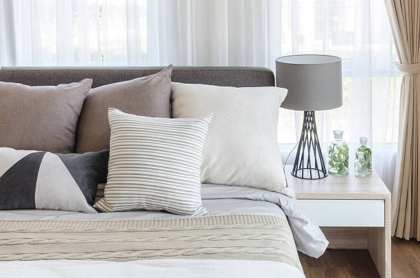 modern style bedroom with pillows on bed modern style bedroom with pillows on bed and modern grey lamp on side table at home bedding stock pictures, royalty-free photos & images