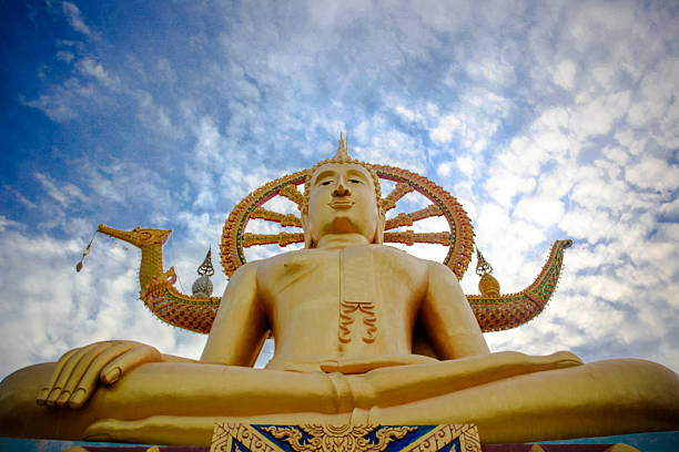 istock golden Buddha statue against blue sky with moving clouds in 484360964