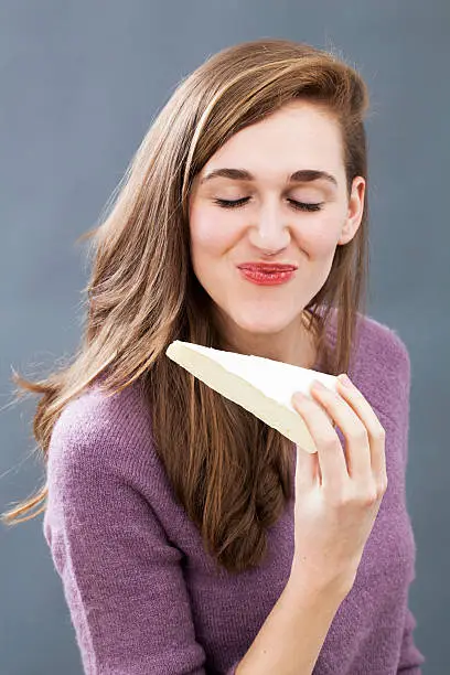 Photo of radiant girl enjoying eating cheese for energy and appetizing food