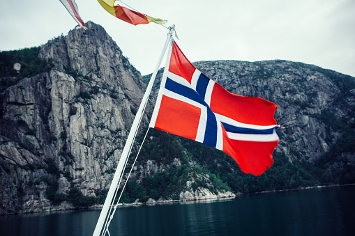 Norwegian flag on a cruising ferry boat in the fjords of Norway. Lysefjorden.