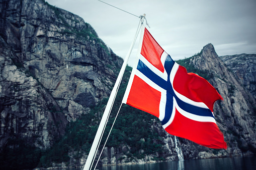 Norwegian flag on a cruising ferry boat in the fjords of Norway. Lysefjorden.