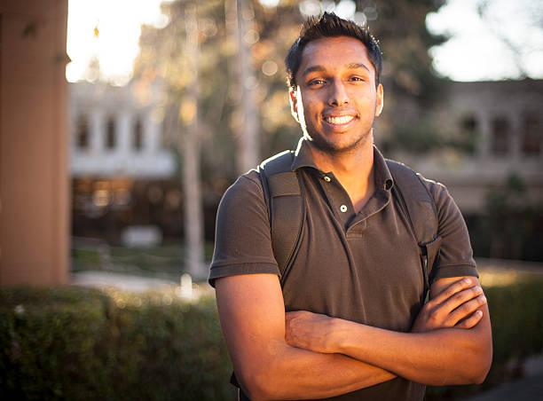 Young Indian College Student Young Indian male college student at University, smiling and looking at camera with his arms folded. sri lankan culture stock pictures, royalty-free photos & images