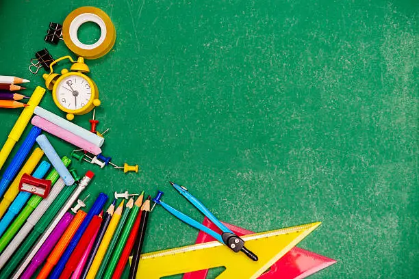Education and back to school concept with school stationery, alarm, crayons, felt pens, pencils and other school objects necessary for successful primary education.