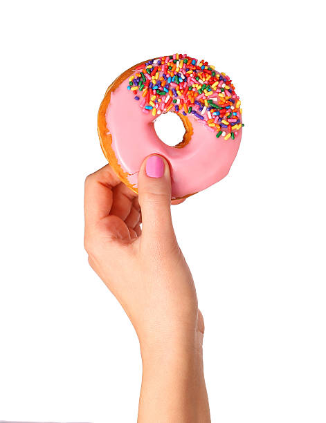 Donut with sprinkles in hand isolated