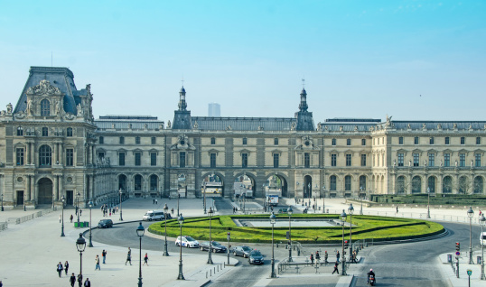 Paris, France - April 11, 2014: The Louvre, Paris,  traffic circle in the center on themuseum buildings. The people are primarily tourists.