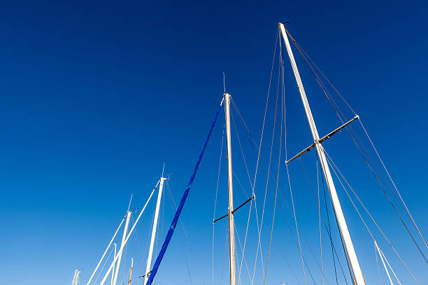 The Mainmasts in the blue sky background. Looking up the mainmasts and blue sky background, around port. gaff rigged stock pictures, royalty-free photos & images