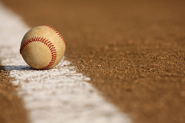 Worn Baseball on the Infield Chalk Line stock photo