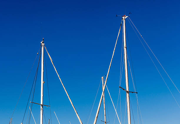 Detail shot of sailing boat poles (mainmasts) in marina. Detail shot of sailing boat poles (mainmasts) in marina. gaff rigged stock pictures, royalty-free photos & images