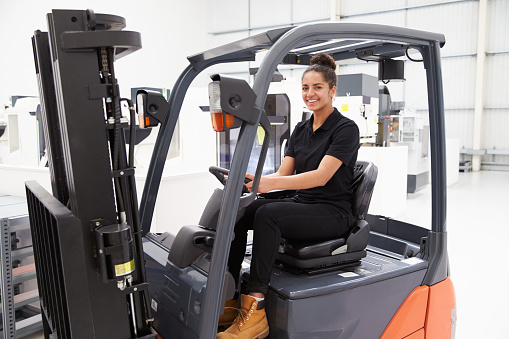 Portrait Of Female Fork Lift Truck Driver In Factory