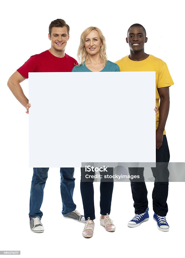 Advertise your business in a modern way Caucasian young woman showing white adverting board while two guys standing beside her Adult Stock Photo