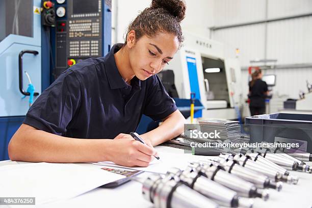 Engineer Planning Project With Cnc Machinery In Background Stock Photo - Download Image Now