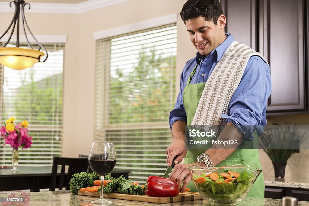 Latin man Prepara la cena en casa cocina.  Hace saludables ensaladas. - Foto de stock de Cocinar libre de derechos