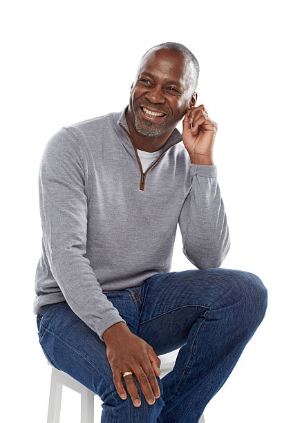 Smiling african man sitting on a stool looking away