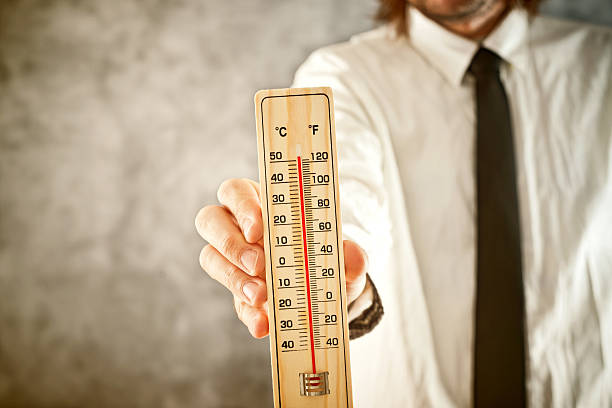 istock Businessman holding thermometer, measuring high temperatures 484377573