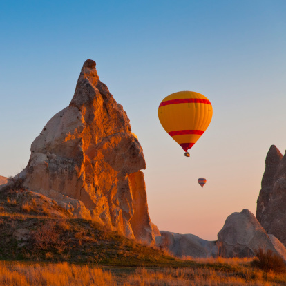 Hot Air Balloons rise up over the Goreme Valley in Cappadocia, Turkey