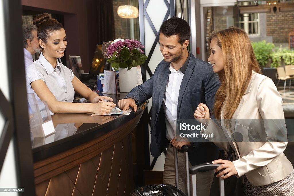 Receptionist and guests at hotel Receptionist giving tourist information to hotel guests upon arrival.. Hotel Reception Stock Photo