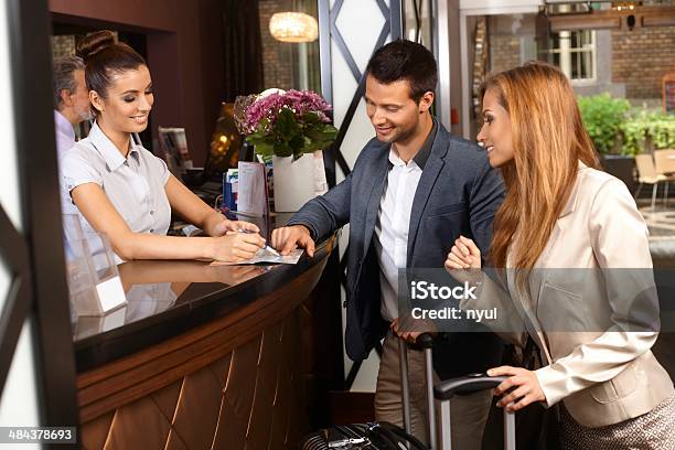 Receptionist And Guests At Hotel Stock Photo - Download Image Now - Hotel Reception, Hotel, Reception Desk