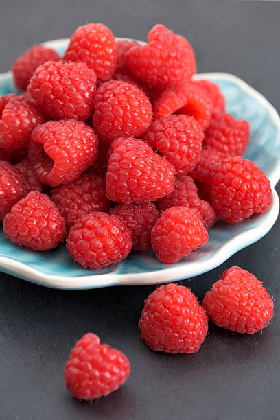 istock Ripe sweet raspberries on a plate on table 484380206
