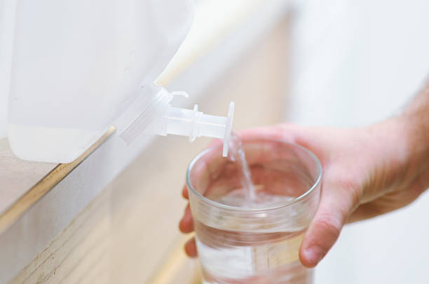 istock Pouring water from nozzle into glass cup 484380254