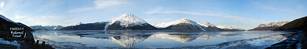 Turnagain Arm Panorama of Chugach Mountains reflecting in Cook Inlet Turnagain Arm Panorama of Chugach Mountains reflecting in Cook Inlet at Chugach State Park along the Seward Highway, Alaska in late March. chugach national forest photos stock pictures, royalty-free photos & images
