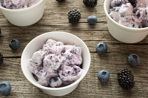 Bowl with curd and fruits of blueberries and blackberries