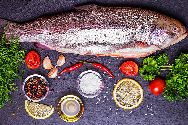 istock Raw trout with spices on a stone background 484393162