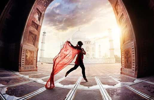 Woman with red scarf dancing near Taj Mahal in Agra, Uttar Pradesh, India