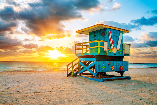 Miami South Beach sunrise Miami South Beach sunrise with lifeguard tower and coastline with colorful cloud and blue sky. south beach stock pictures, royalty-free photos & images