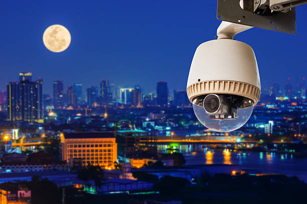CCTV or Survillance security camera operating with city in background stock photo
