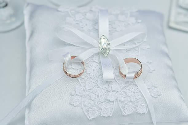 anillos de boda en almohada raso blanco - necklate fotografías e imágenes de stock