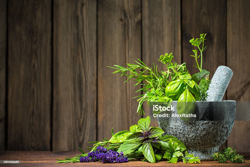 Mortar with herbs Mortar with herbs on wooden table Herbal Medicine Stock Photo