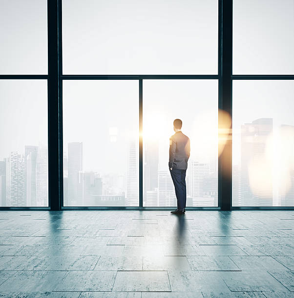 istock Businessman looking at sunrise in the loft 484411480