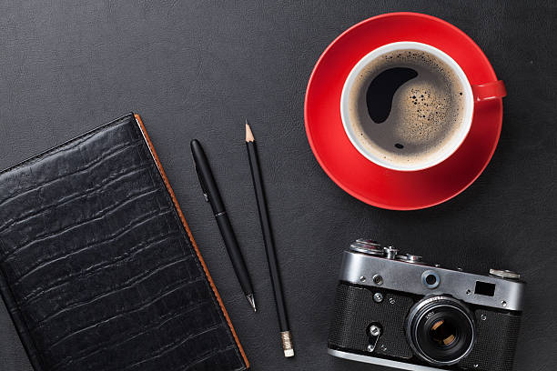 istock Desk with camera, supplies and coffee cup 484414734