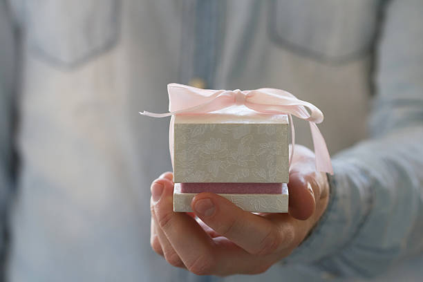 istock Man hand holding engagement ring in the white gift box 484420426