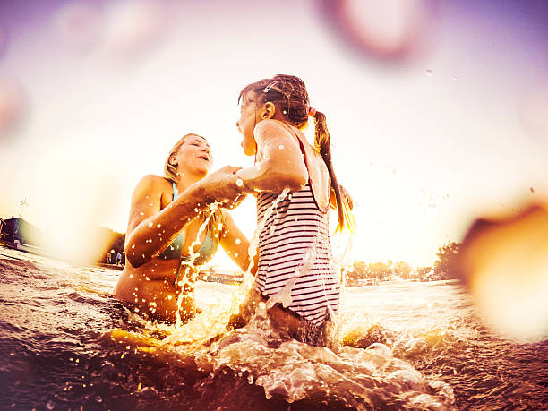 istock Family playing in river with water splashes 484420516