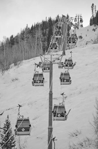 Vail, United States - January 10, 2015: the Vail ski gondola is photographed transporting skiers up the mountain for a day of powder skiing.  Pictured in black and white, it congers up images of the ski resort when it was founded in 1962.