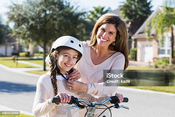 Mother Helping Daughter With Bike Helmet Strap Stock Photo - Download Image Now - Bicycle, Cheerful, Cycling