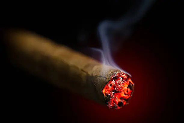 burning cigar on red glowing background