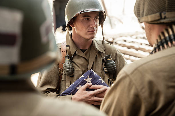 istock WWII Soldier Holds Flag and Pays Respects with Platoon 484427192