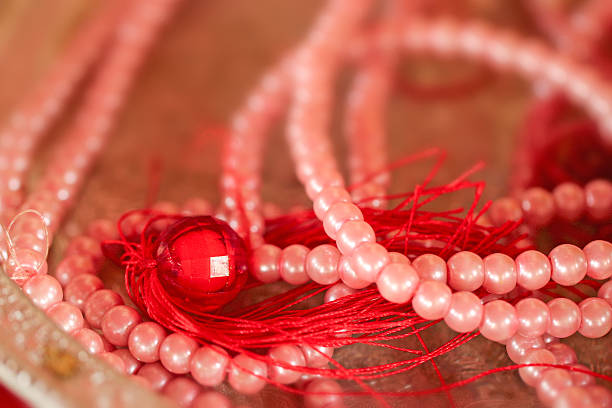 Beads in the shape of a necklace on a wooden table.