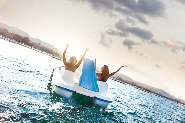 Best friend enjoying summer and pedalo fun Best friend enjoying summer and pedalo fun during vacations. paddleboat stock pictures, royalty-free photos & images