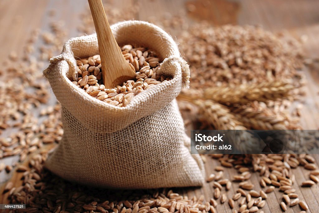 spelled seeds in the bag spelled seeds into the bag on the wooden table Agriculture Stock Photo