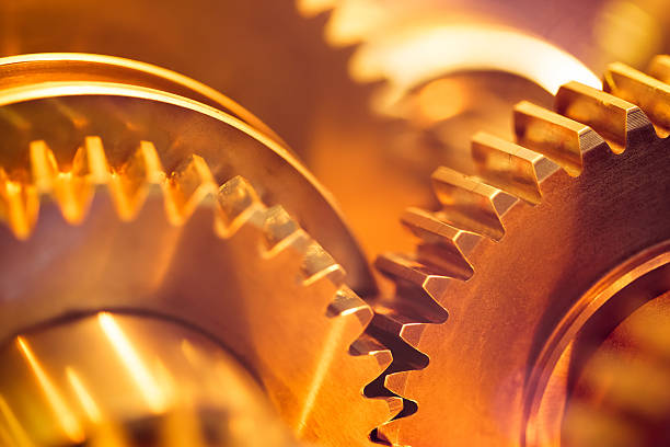 golden gear wheels golden gear wheels with cogs, close-up clockworks photos stock pictures, royalty-free photos & images